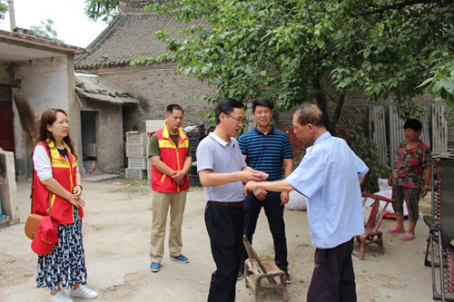 图为市残联党组书记到辛安镇茨元黄村贫困户家中走访，并送去慰问金