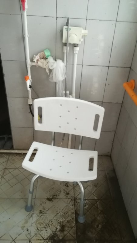 图为为残疾人发放助行器和沐浴椅
